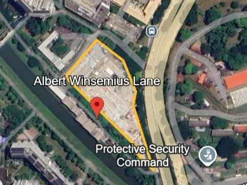 Satellite map of the Albert Winsemius Lane site, outlined in yellow beside a canal and an elevated road, with the Protective Security Command to the south